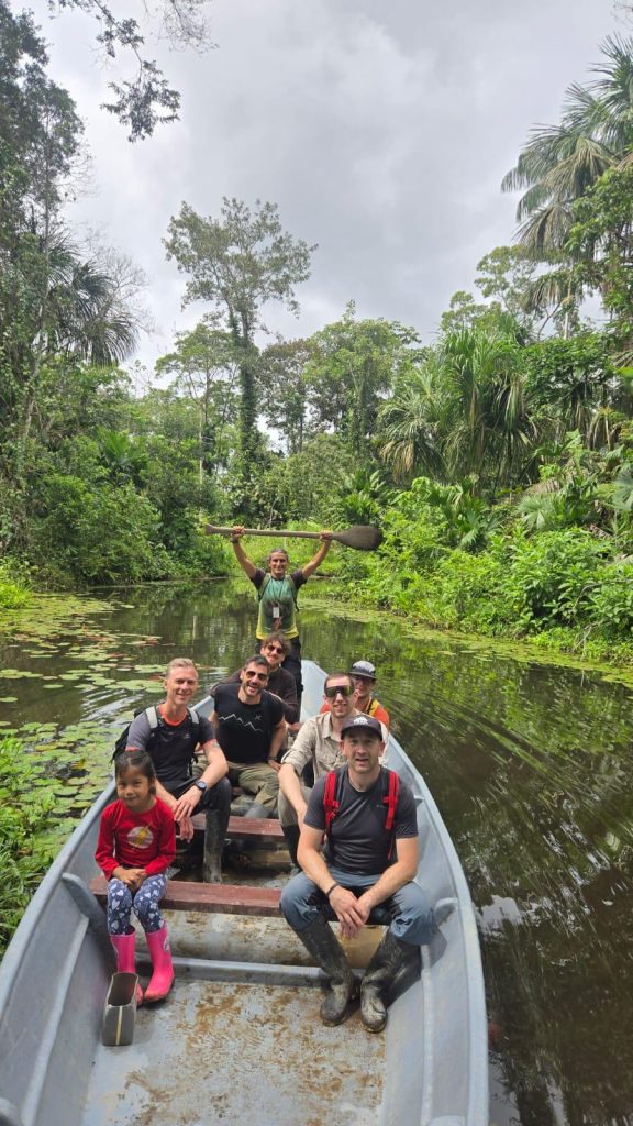 Travellers in a canoe on a lily-covered Amazon channel