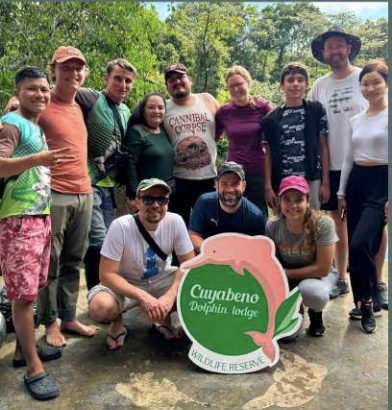 Guests with the Cuyabeno Dolphin Lodge sign in the reserve